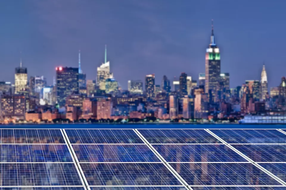 Solar panels with blurred twilight view of New York City skyline witrh Empire State Building in background
